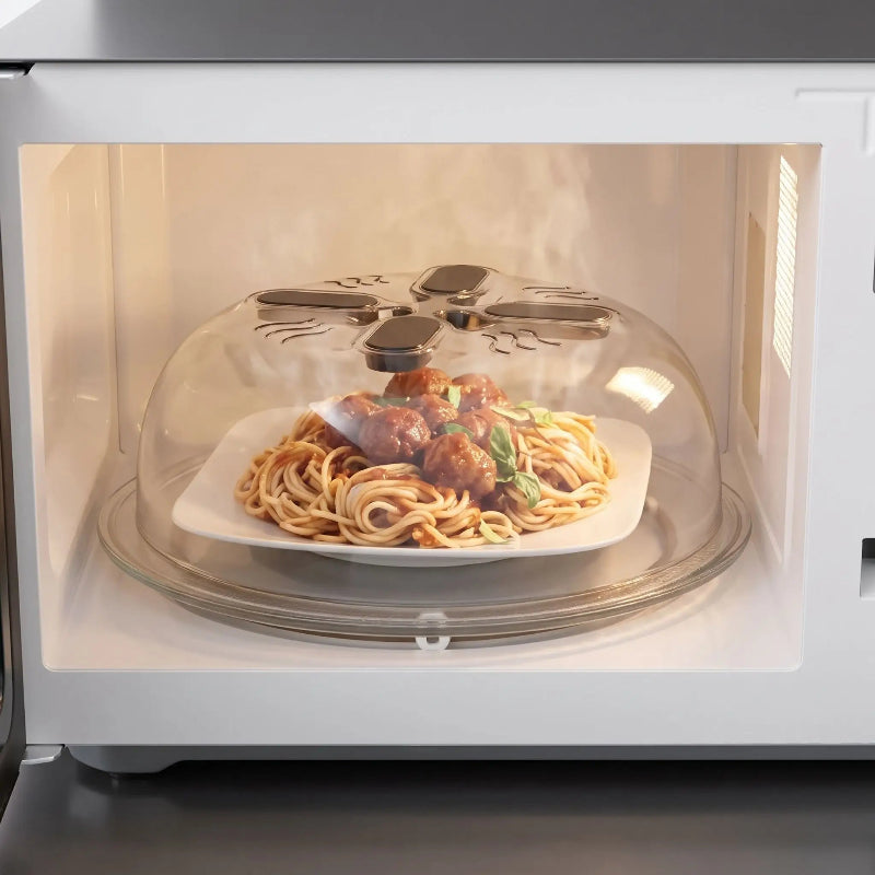 Cloche micro onde transparente couvrant une assiette de spaghettis aux boulettes pour limiter les éclaboussures pendant le réchauffage.
