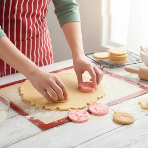 maman faisant des des pates a biscuit avec Emporte piece noel