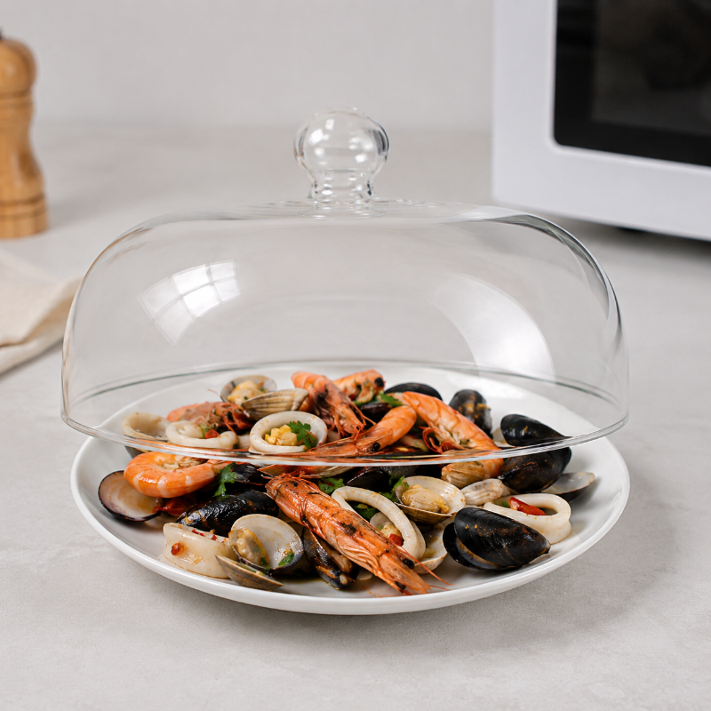 Cloche micro onde en verre entrouverte sur une assiette de fruits de mer