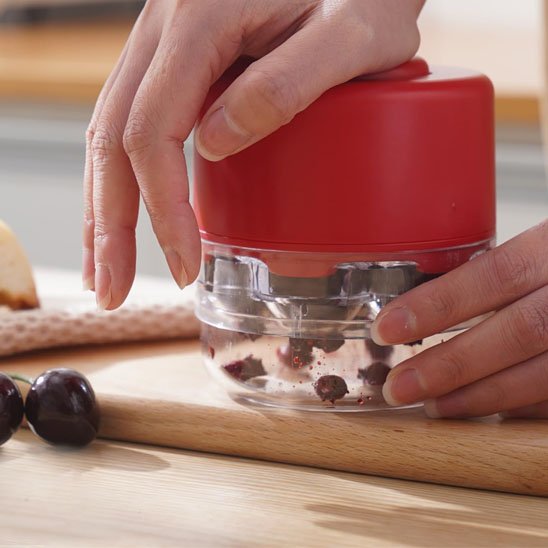 Denoyauteur cerise rouge sur une planche à découper bois