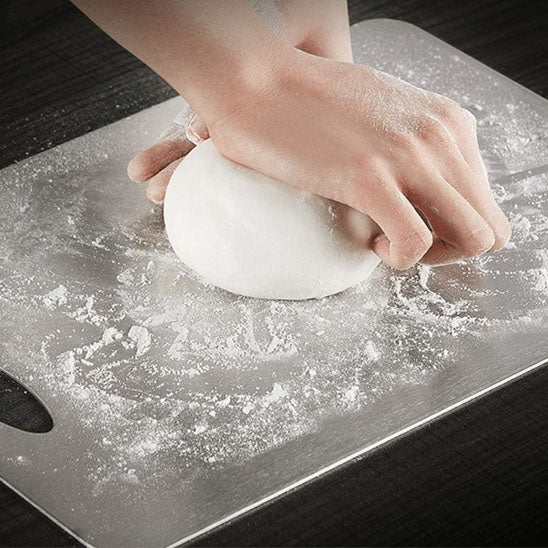 planche a decouper mains avec une boule de pate