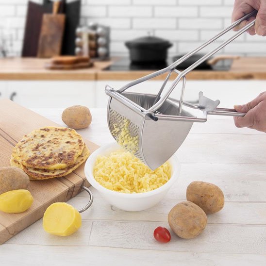 Presse purée sur un plan de travail avec des pomme de terre