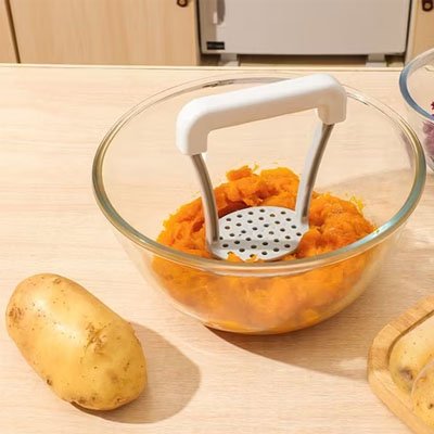 presse purée dans un bol transparent de patate douce