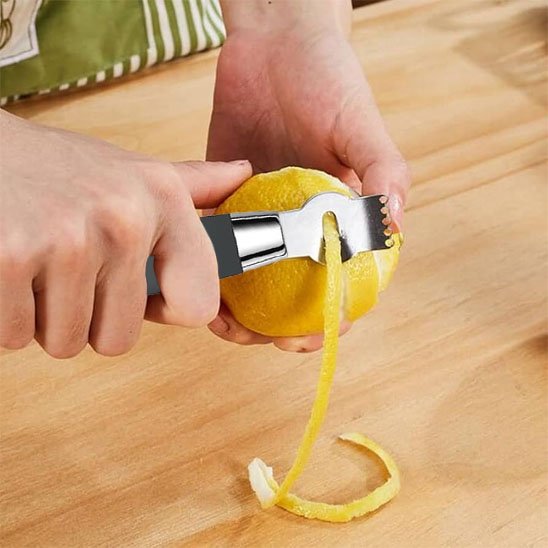 Zesteur un homme utilise un zesteur pour peler une orange